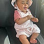 baby, child, smiling, hat, pink_clothing, pacifier, car_seat, cute, happy, infant, sitting, cherry_pattern, tongue_out, indoors, seatbelt, young_child, human, adorable, cheerful, portrait