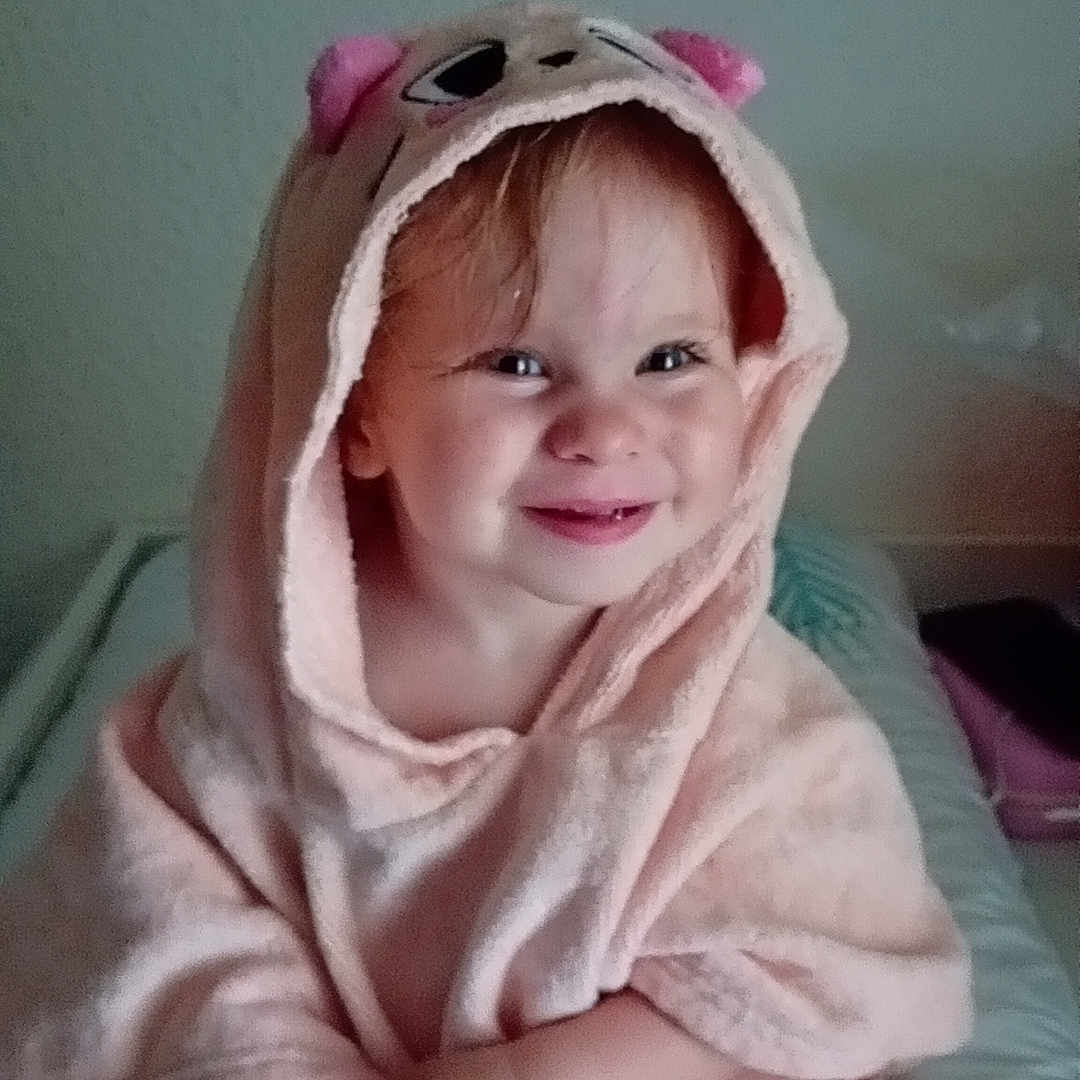 Wendy a rejoint le concours — aidez-le/la à gagner de superbes lots ! baby, bed, blanket, child, clothing, cozy, cute, expression, face, happy, hooded_towel, indoor, person, pink, portrait, sitting, skin, smile, toddler, young_child