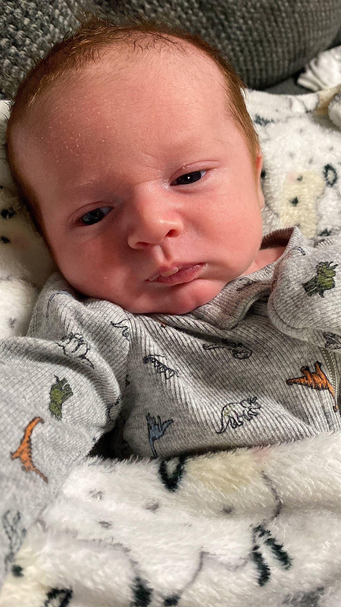 Hunter is registered to the contest to win money with this photo: baby, baby_toddler_clothing, cheek, child, chin, close_up, comfort, facial_expression, grass, happy, linens, lip, mouth, nose, pattern, person, skin, sleeve, smile, textile