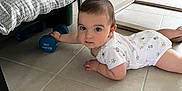 Gabin participe au concours pour gagner de l'argent avec cette photo : baby, infant, floor, tile, dumbbell, indoor, furniture, cushion, child, person, white_clothing, looking, hand, exercise, weight, curious, lying_down, flooring, home, playful