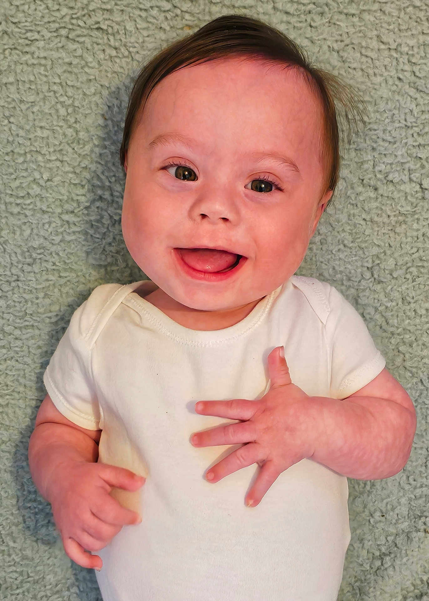 Jason joined the competition — help win amazing prizes! baby, smile, infant, child, white_onesie, happy, face, portrait, lying_down, hands, cute, skin, hair, eyes, expression, young, toddler, background, texture, blanket