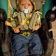 Bradlee joined the competition — help win amazing prizes! baby, blue, car_seat, child, clothing, cute, face, floor, hoodie, indoor, infant, jeans, pacifier, person, plaid, seat_belt, socks, wood_floor, yellow, young_child