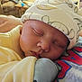 Bradlee joined the competition — help win amazing prizes! baby, sleeping, hat, yellow_clothing, close_up, infant, resting, face, peaceful, cozy, adult_arm, indoor, soft_lighting, cute, newborn, portrait, comfort, person, headwear, tender