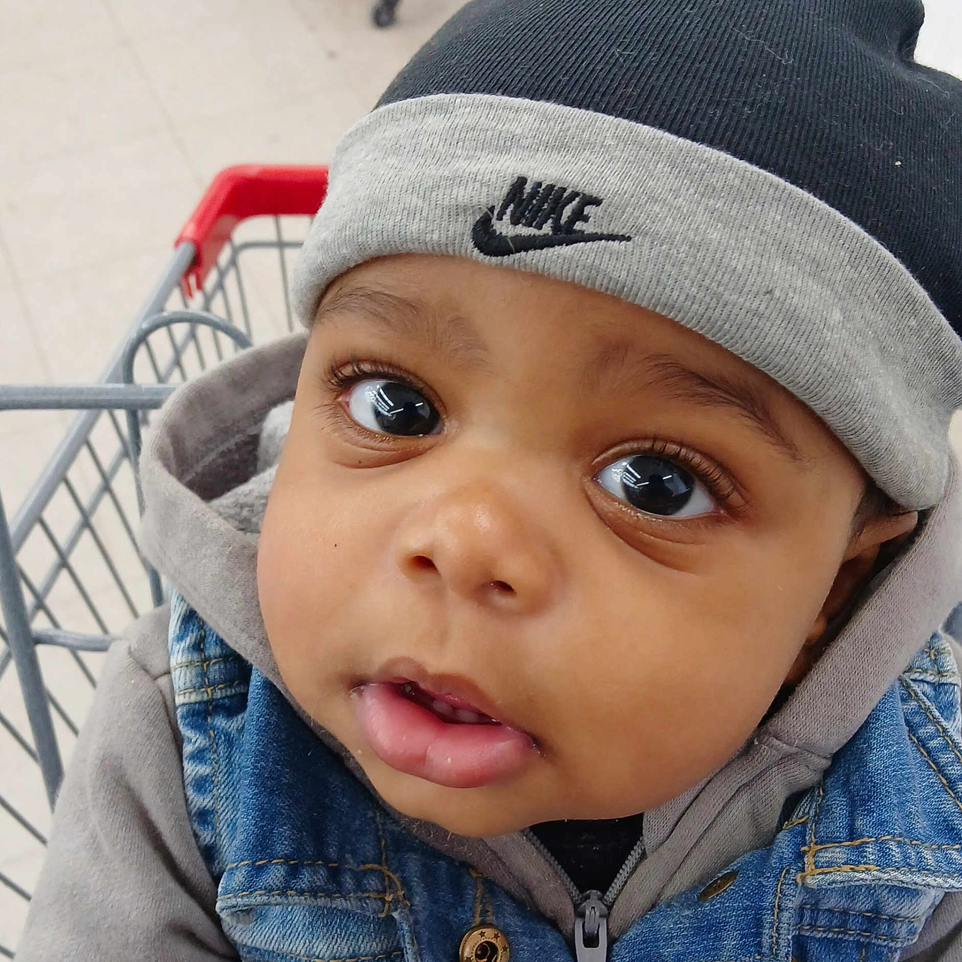 Baleel joined the competition — help win amazing prizes! baby, beanie, child, closeup, clothing, curious, cute, denim_jacket, expression, eyes, face, hat, headwear, hoodie, indoor, nike, person, portrait, shopping_cart, skin