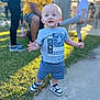 blue_shirt, blurred_background, casual, child, clothing, daylight, grass, happy, hat, man, outdoor, park, people, person, playground, shorts, sidewalk, sneakers, toddler, yellow_shirt
