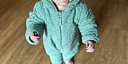 Ryder is registered to the contest to win money with this photo: apparel, baby, barefoot, child, cute, eyes, face, fuzzy_texture, green_clothing, happy, hood, hoodie, indoor, infant, one_person, portrait, smiling, standing, toddler, wooden_floor