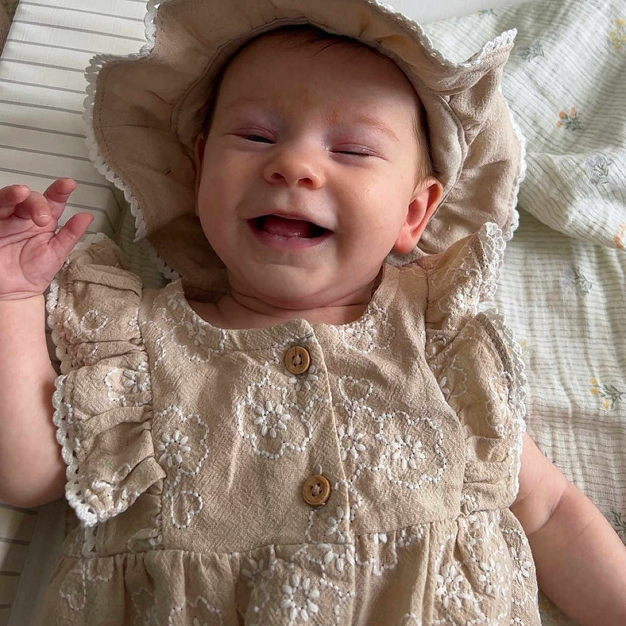 Lottie Mae joined the competition — help win amazing prizes! baby, beige, blanket, button, child, clothing, cute, dress, fabric, floral, hand, happy, hat, indoors, infant, lying_down, pattern, person, portrait, smile