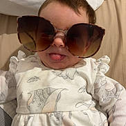 Lottie Mae joined the competition — help win amazing prizes! baby, child, sunglasses, tongue, cute, playful, bed, pillow, clothing, infant, person, portrait, indoors, smile, fashion, young, face, hand, sleepwear, soft