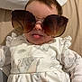 baby, child, sunglasses, tongue, cute, playful, bed, pillow, clothing, infant, person, portrait, indoors, smile, fashion, young, face, hand, sleepwear, soft