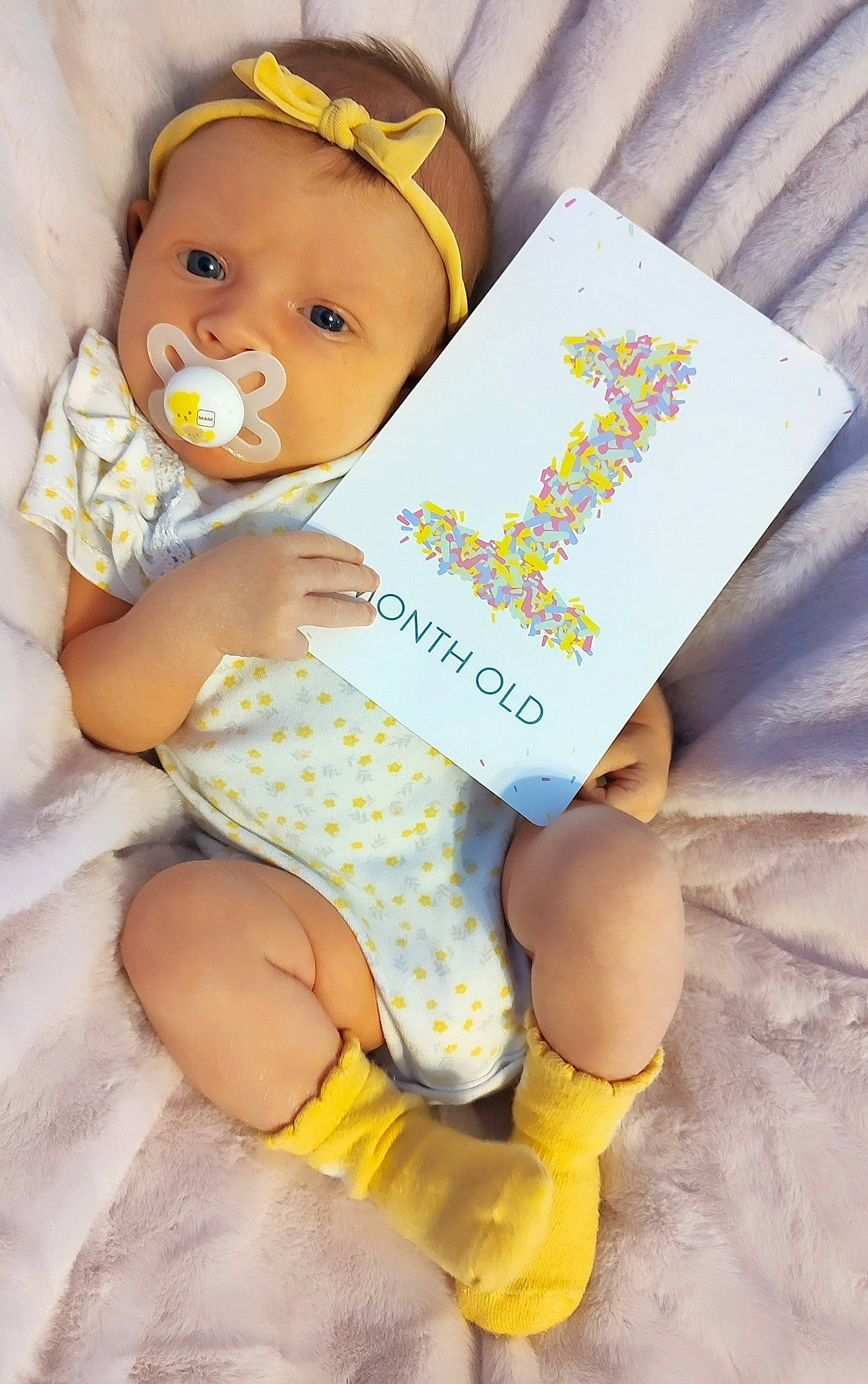 Aina is registered to the contest to win money with this photo: baby, baby_toddler_clothing, cap, child, electric_blue, finger, gesture, hand, happy, headwear, human_leg, knee, nail, person, publication, skin, sock, thigh, thumb, toy