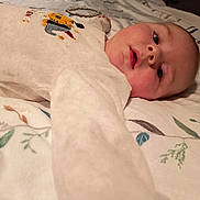 Thoryan a rejoint le concours — aidez-le/la à gagner de superbes lots ! baby, infant, onesie, blanket, pattern, face, hand, lying_down, cute, soft_lighting, indoor, child, expression, closeup, skin, person, sleepwear, embroidery, cozy, portrait