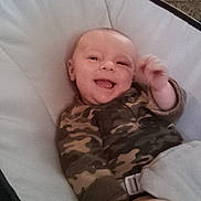 Alykie is registered to the contest to win money with this photo: baby, infant, smiling, camo_pajamas, baby_seat, indoor, cozy, happy, child, person, furniture, couch, seat, comfort, cute, portrait, skin, hand, face, relaxing