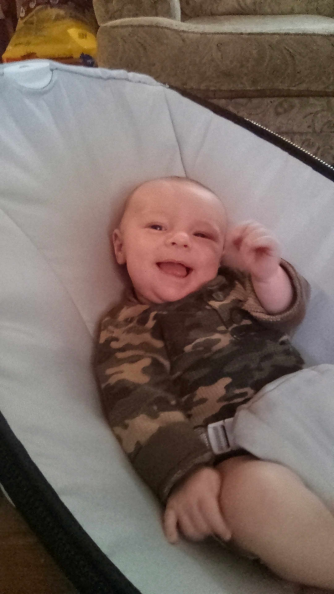 Alykie is registered to the contest to win money with this photo: baby, infant, smiling, camo_pajamas, baby_seat, indoor, cozy, happy, child, person, furniture, couch, seat, comfort, cute, portrait, skin, hand, face, relaxing