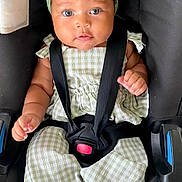 Sia participe au concours pour gagner de l'argent avec cette photo : baby, child, car_seat, green_bow, green_outfit, straps, sitting, cute, portrait, infant, face, headband, clothing, hands, feet, indoor, secure, looking_at_camera, expression, closeup