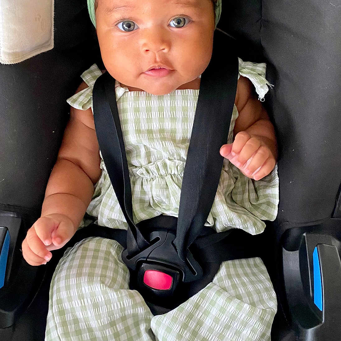 Sia participe au concours pour gagner de l'argent avec cette photo : baby, car_seat, child, closeup, clothing, cute, expression, face, feet, green_bow, green_outfit, hands, headband, indoor, infant, looking_at_camera, portrait, secure, sitting, straps