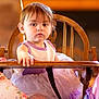 Miley joined the competition — help win amazing prizes! child, toddler, high_chair, dress, purple, white, wooden_chair, indoor, curious, face, person, young, sitting, baby, clothing, furniture, portrait, soft_light, casual, home