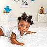 Delijah joined the competition — help win amazing prizes! baby, infant, child, lying_down, white_rug, curly_hair, plush_toy, cookie_jar, minimalist_background, indoor, cute, portrait, floor, decor, expression, curious, skin, socks, white_clothing, playful