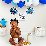 Delijah is registered to the contest to win money with this photo: baby, child, cookie, milk, balloons, blue, white, diaper, floor, toy, decoration, celebration, milestone, plush, jar, cute, sitting, portrait, happy, indoor