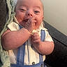 Warren is registered to the contest to win money with this photo: baby, infant, smile, face, hand, clothing, shirt, suspenders, blue, white, blanket, couch, happy, cute, child, human, skin, indoor, portrait, cozy