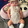 Warren is registered to the contest to win money with this photo: baby, infant, child, romper, hat, socks, pillow, cartoon, bed, blanket, cute, smiling, person, indoor, clothing, face, hands, legs, comfort, rest