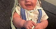 Warren is registered to the contest to win money with this photo: baby, child, infant, smiling, sitting, clothing, shirt, suspenders, couch, blanket, furniture, indoors, happy, cute, portrait, skin, hand, face, young, relaxing