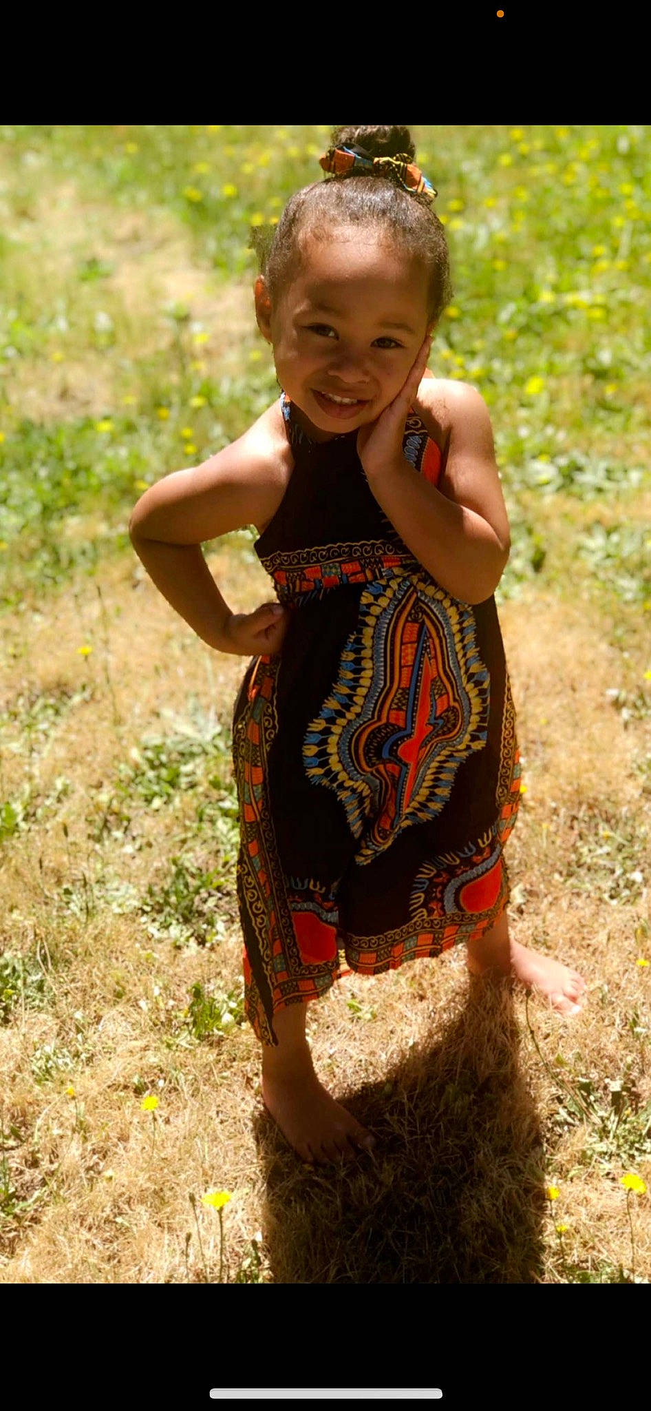 Amiyah is registered to the contest to win money with this photo: baby_toddler_clothing, brown_hair, day_dress, eye, fawn, fun, grass, happy, human_leg, joy, pattern, people_in_nature, person, plant, sleeve, smile, soil, t_shirt, thigh, toddler