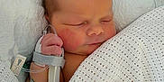 Ocean is registered to the contest to win money with this photo: newborn, baby, blanket, white, sleeping, hospital, medical_tube, hand, face, infant, cozy, wrapped, bed, skin, peaceful, cute, patient, healthcare, soft, resting