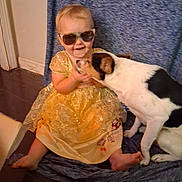 Sara-Lynn joined the competition — help win amazing prizes! toddler, child, dog, yellow_dress, sunglasses, indoor, floor, blanket, cute, pet, smile, friendship, playful, barefoot, young_child, animal, happy, portrait, sitting, affection