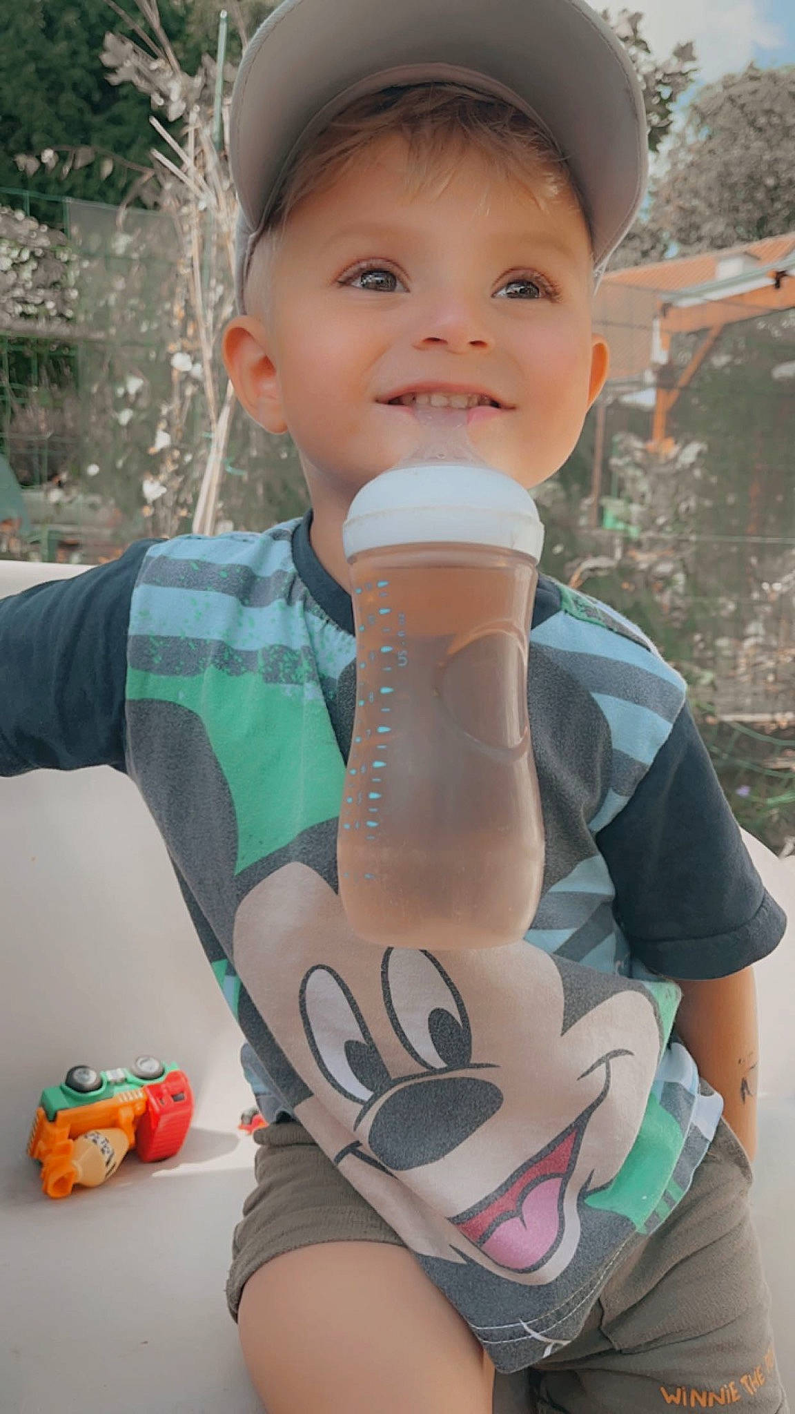 Mylhan participe au concours pour gagner de l'argent avec cette photo : baby_toddler_clothing, cap, chest, child, drinkware, finger, fun, glove, happy, head, joy, leisure, person, personal_protective_equipment, recreation, skin, sleeve, smile, t_shirt, temporary_tattoo
