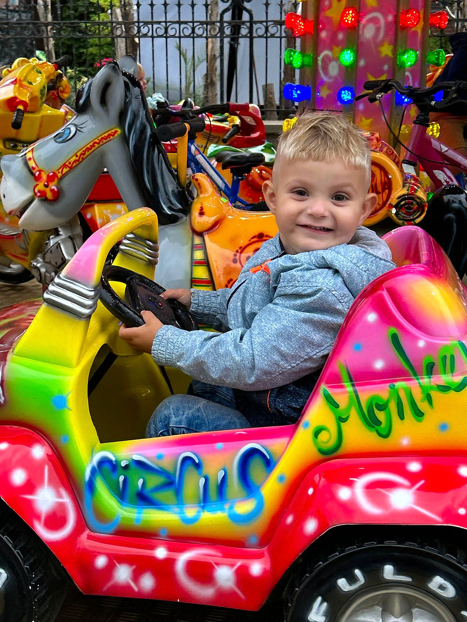 Mylhan a rejoint le concours — aidez-le/la à gagner de superbes lots ! automotive_design, automotive_tire, baby, child, eye, facial_expression, fun, green, joy, leisure, mode_of_transport, motor_vehicle, person, photograph, riding_toy, smile, tire, toddler, vehicle, wheel