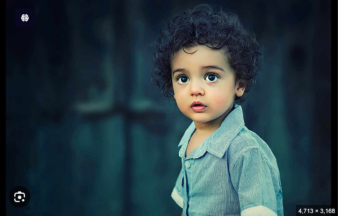 Lol joined the competition — help win amazing prizes! child, toddler, curly_hair, blue_shirt, portrait, face, wide_eyes, expression, innocence, young_child, person, standing, casual_clothing, curious, background_blur, closeup, skin, head, looking_away, indoors