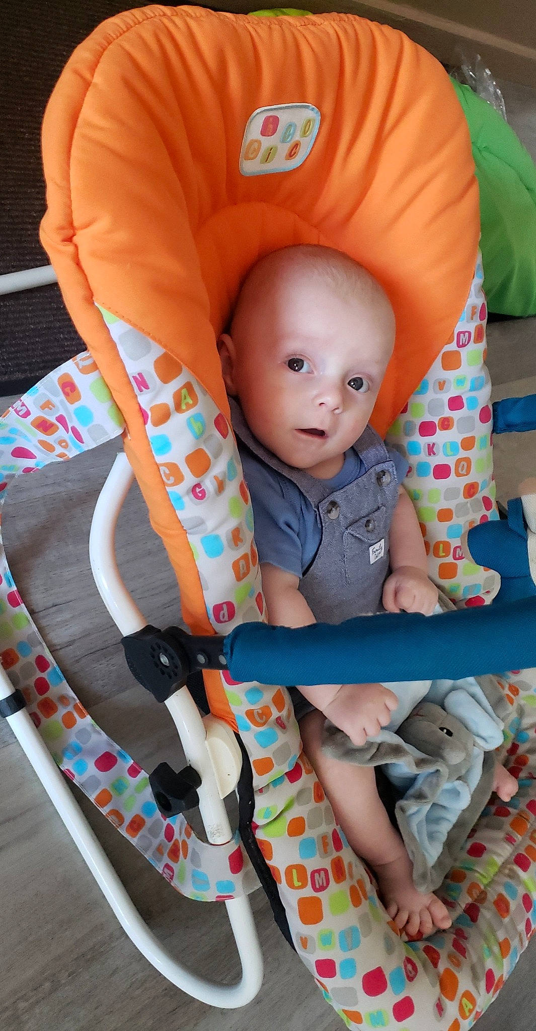 Carlos participe au concours pour gagner de l'argent avec cette photo : arm, baby, baby_carriage, baby_products, baby_safety, baby_toddler_clothing, chair, child, comfort, linens, orange, pattern, person, pink, play, product, sitting, sleeve, textile, toddler