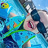 child, pool, water, floaties, sunglasses, happy, smiling, summer, outdoor, blue_sky, clouds, swimming, fun, sunny, splash, vacation, playful, life_jacket, dinosaur_pattern, inflatable