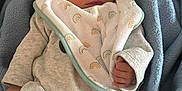 Mayron participe au concours pour gagner de l'argent avec cette photo : newborn, baby, sleeping, blanket, bib, rainbow_pattern, cozy, soft, clothing, socks, striped_socks, infant, cute, resting, indoors, portrait, peaceful, baby_clothes, toddler, closeup