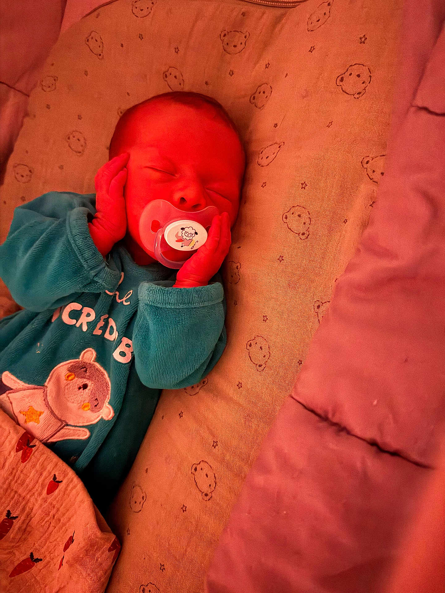 Mayron participe au concours pour gagner de l'argent avec cette photo : newborn, baby, sleeping, pacifier, blanket, bed, cute, cozy, infant, child, wearing_clothes, teal_outfit, bear_design, hands_on_face, resting, indoors, soft_lighting, portrait, peaceful, toddler