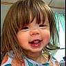 Elizabeth is registered to the contest to win money with this photo: child, toddler, girl, smiling, happy, portrait, face, long_hair, brown_hair, eyes, teeth, indoor, home, window, curtain, shirt, colorful_clothing, close_up, candid, daylight
