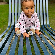 Janelle participe au concours pour gagner de l'argent avec cette photo : baby, child, bench, outdoor, grass, greenery, clothing, pink, polka_dot, socks, cute, person, face, portrait, young_child, nature, garden, metal_bench, sitting, curious