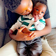 Zayden joined the competition — help win amazing prizes! child, baby, couch, affection, love, family, indoor, clothing, striped_shirt, jeans, socks, hair, holding, kiss, seated, comfort, skin, portrait, toddler, sibling