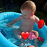 toddler, child, pool, water, splashing, toy, inflatable_pool, blue, sunlight, outdoor, summer, barefoot, hand, playing, motorcycle, grass, garden, happy, skin, cute