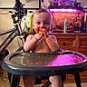 Mateo joined the competition — help win amazing prizes! baby, high_chair, messy, food, face, hands, bicycle, fish_tank, purple_light, red_light, indoor, carpet, wooden_drawer, curious, child, person, smile, plate, feeding, home