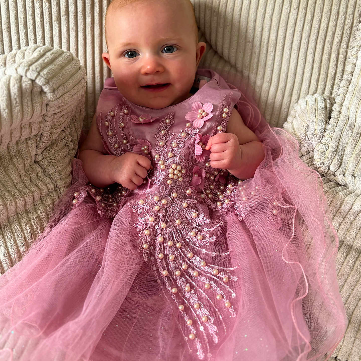 Léna participe au concours pour gagner de l'argent avec cette photo : baby, child, closeup, couch, cute, decorative, fabric, face, furniture, happy, indoors, pearls, person, pink_dress, portrait, sitting, smile, soft_lighting, texture, young_child