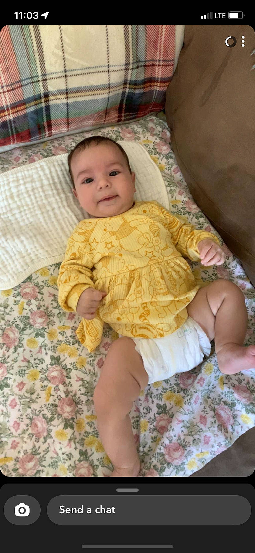 Rayleigh is registered to the contest to win money with this photo: baby, baby_toddler_clothing, cheek, child, comfort, couch, dress, fun, happy, head, human_leg, lap, linens, pattern, person, sitting, skin, sleeve, smile, thigh