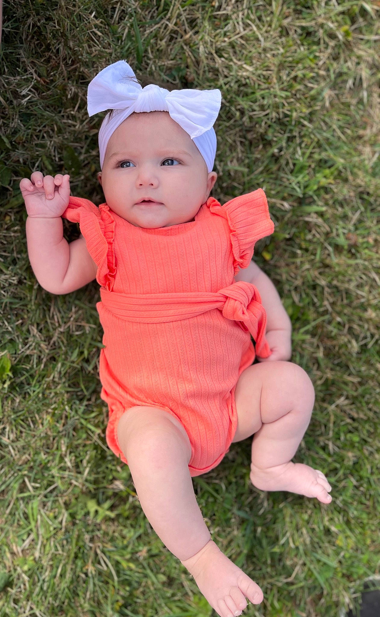 Karter is registered to the contest to win money with this photo: baby, baby_toddler_clothing, botany, cap, eye, face, finger, grass, grass_family, hand, head, headwear, human_body, leaf, lip, people_in_nature, person, pink, plant, skin