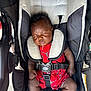 Robert is registered to the contest to win money with this photo: baby, infant, sleeping, stroller, harness, red_outfit, sneakers, child, cute, peaceful, closeup, black_hair, outdoor, comfort, seat, straps, young_child, resting, person, footwear