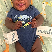 Robert joined the competition — help win amazing prizes! baby, blanket, celebration, child, close_up, colorful, cute, dinosaur_onesie, giraffe_pattern, hands, happy, indoors, infant, legs, lying_down, months_sign, portrait, smiling, tongue_out, wooden_block