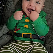 Nikodem is registered to the contest to win money with this photo: baby, child, smiling, green_clothing, striped_pants, seat, cushion, happy, face, infant, cute, indoor, portrait, hand, playful, young_child, holiday_outfit, cozy, person, expression