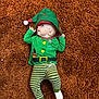 baby, carpet, child, christmas, cozy, cute, elf_hat, face, festive, green_clothing, holiday_outfit, indoor, infant, lying_down, portrait, smiling, soft_texture, striped_pants, white_socks, young_child