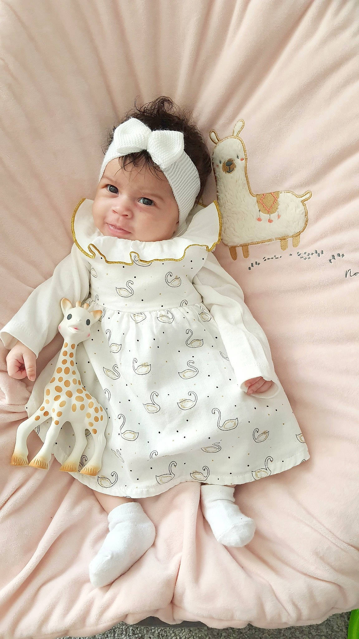 Liliana participe au concours pour gagner de l'argent avec cette photo : baby, baby_products, baby_toddler_clothing, child, clothing, doll, dress, embellishment, fur, hair_accessory, headband, headwear, linens, outerwear, pattern, peach, person, pink, skin, sleeve