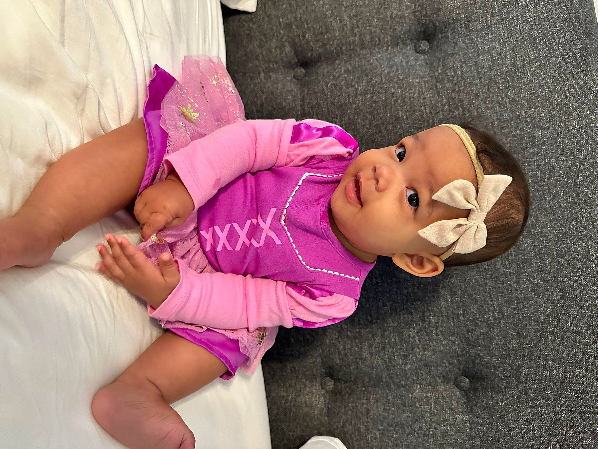 Sadie joined the competition — help win amazing prizes! baby, baby_toddler_clothing, child, comfort, eye, glasses, happy, headgear, headwear, human_body, human_leg, knee, linens, magenta, person, pink, purple, skin, thigh, toddler