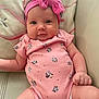 baby, infant, pink_bow, onesie, minnie_mouse, headband, cute, chubby_cheeks, couch, indoor, portrait, child, smiling, clothing, person, closeup, soft_lighting, relaxed, young, adorable